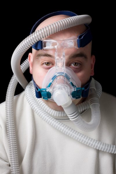 Sleep apnea dental patient wearing CPAP breathing mask in Layton, UT